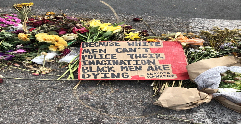 A hand-painted cardboard sign with the words 'Because White Men Can't Police Their Imagination Black Men Are Dying' -- Claudia Rankine